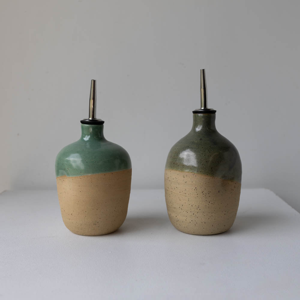 Two Lil Ceramics Sage green and Kelp Green handmade oil pourers a white surface.